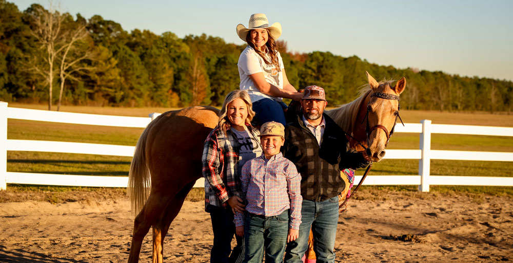 The Nipper family posing next to Ella and her palomino horse. 